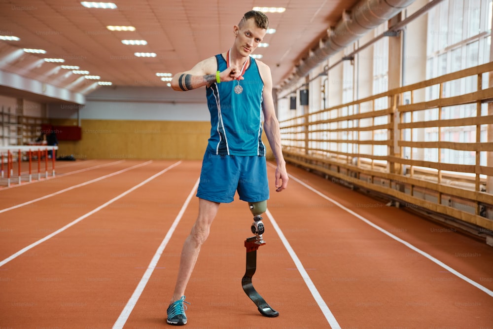 a man in a blue shirt and blue shorts standing on a track