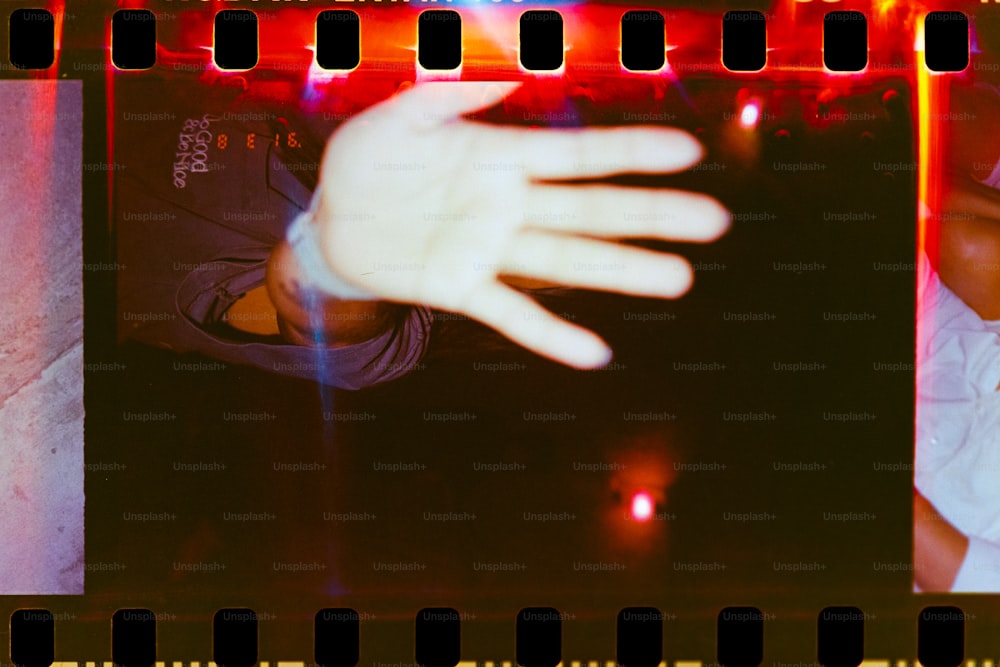 eine Hand, die sich aus einem Filmstreifen ausstreckt