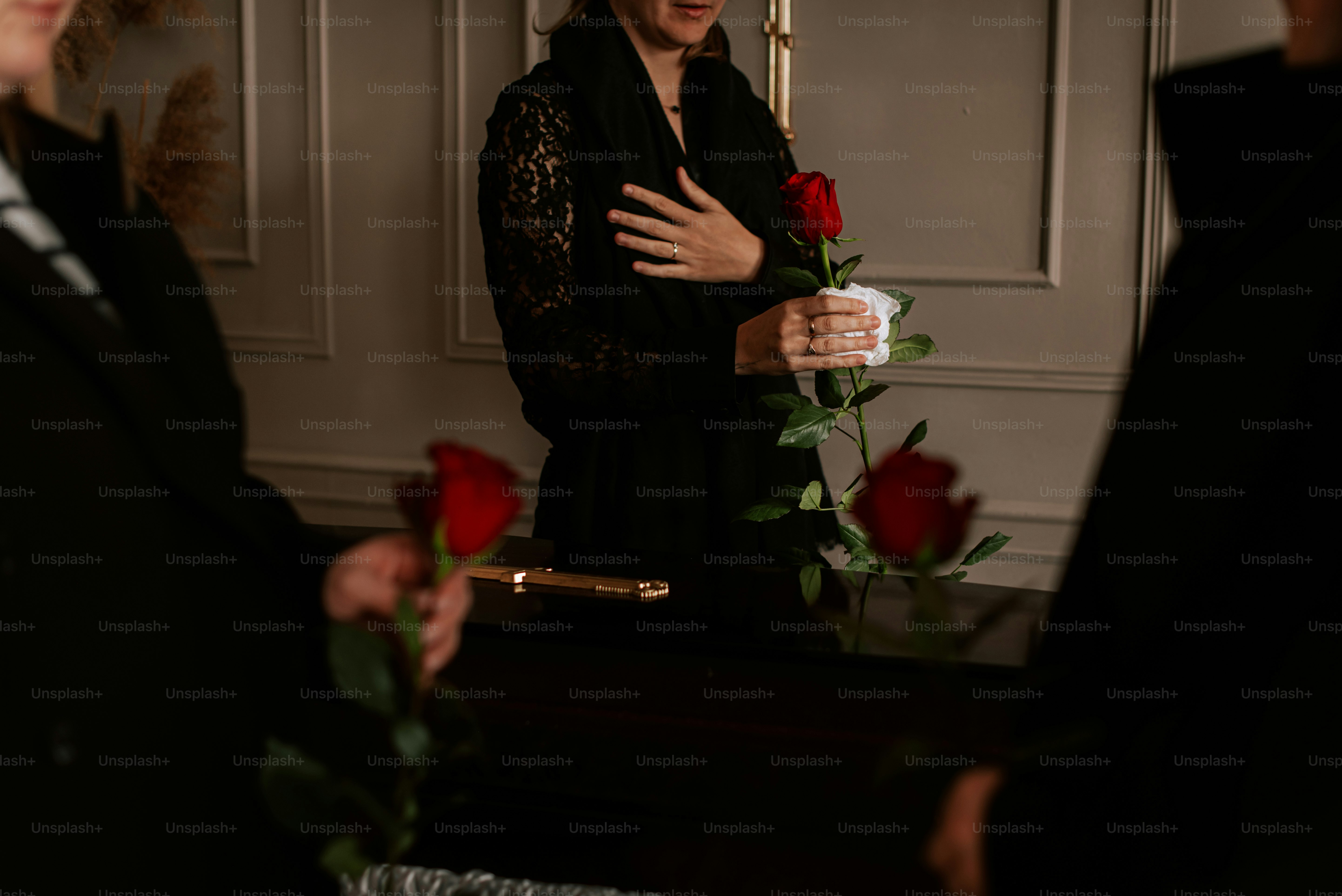 eine Frau in einem schwarzen Kleid mit einer Rose in der Hand