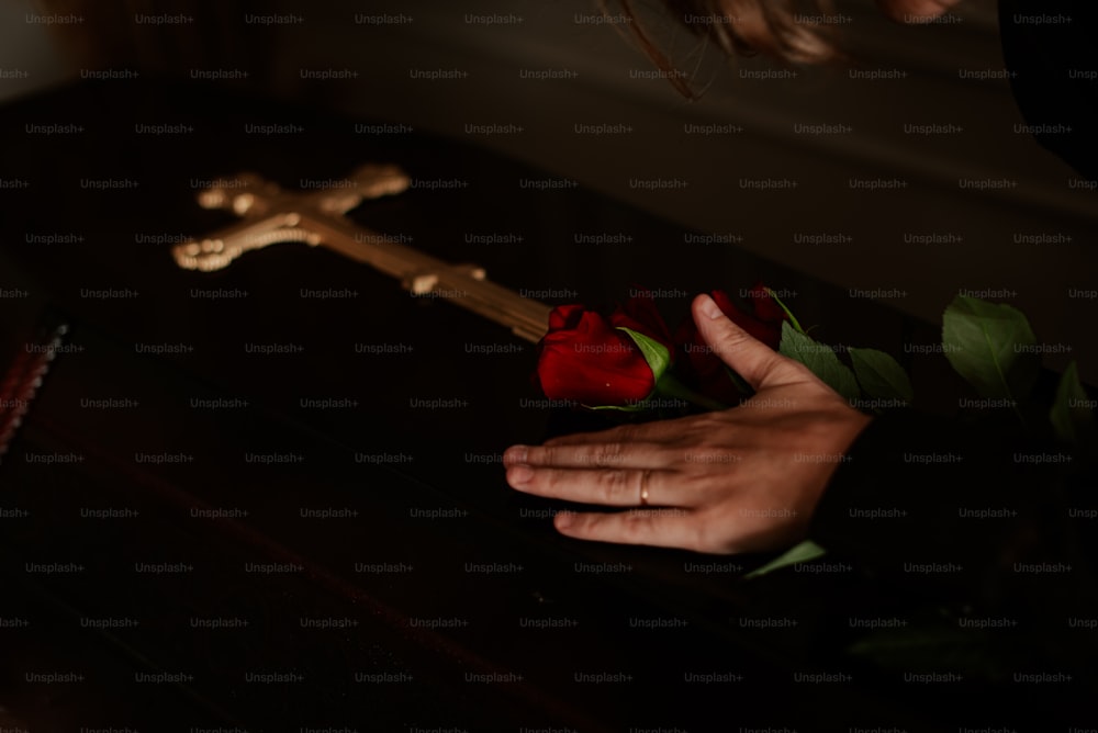 a person placing a rose on a cross