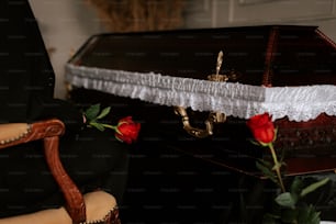 a rose sits on a chair next to a casket