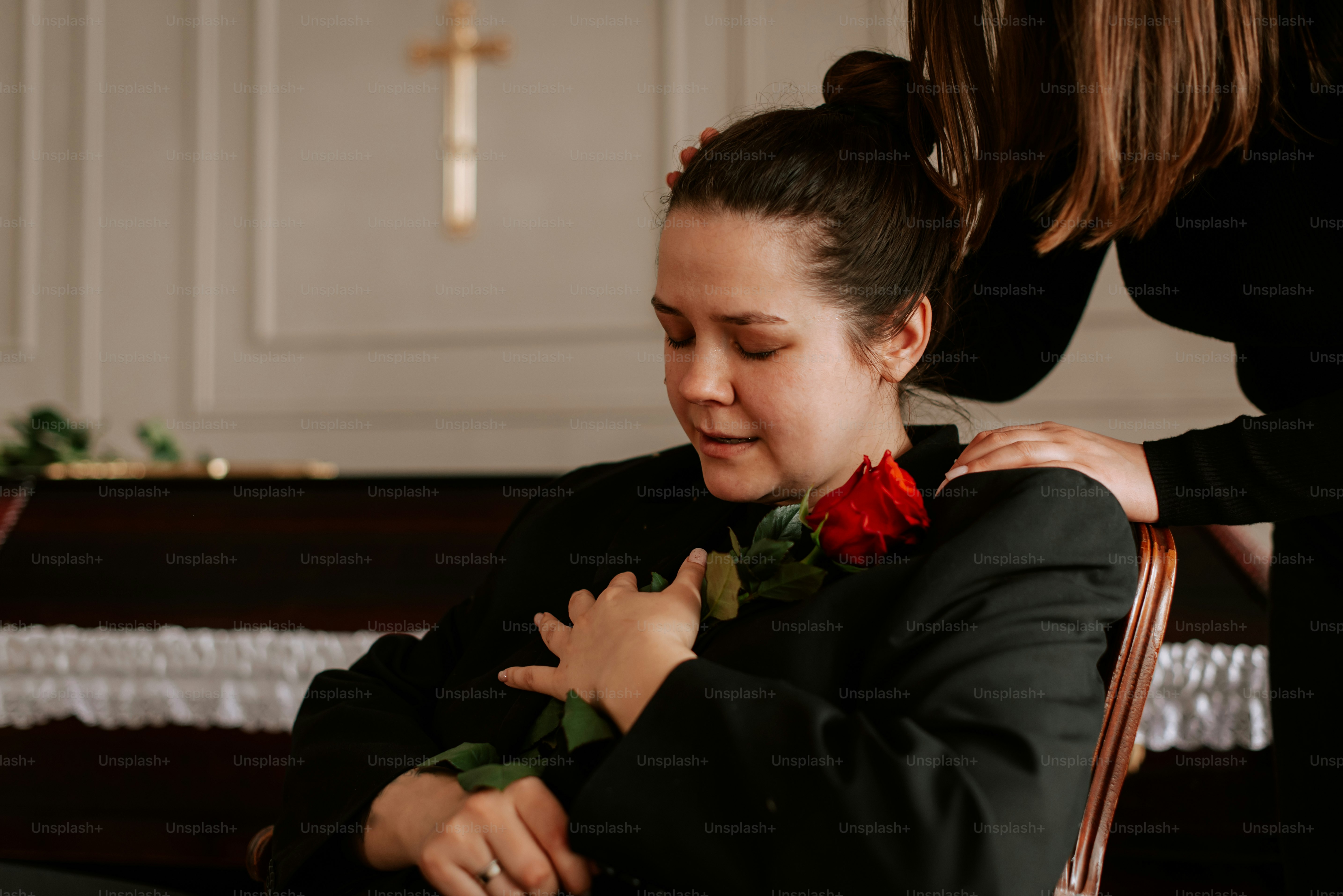 a woman in a black jacket is holding a red rose