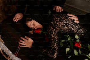 eine Frau, die mit einer Rose in der Hand auf einem Tisch liegt