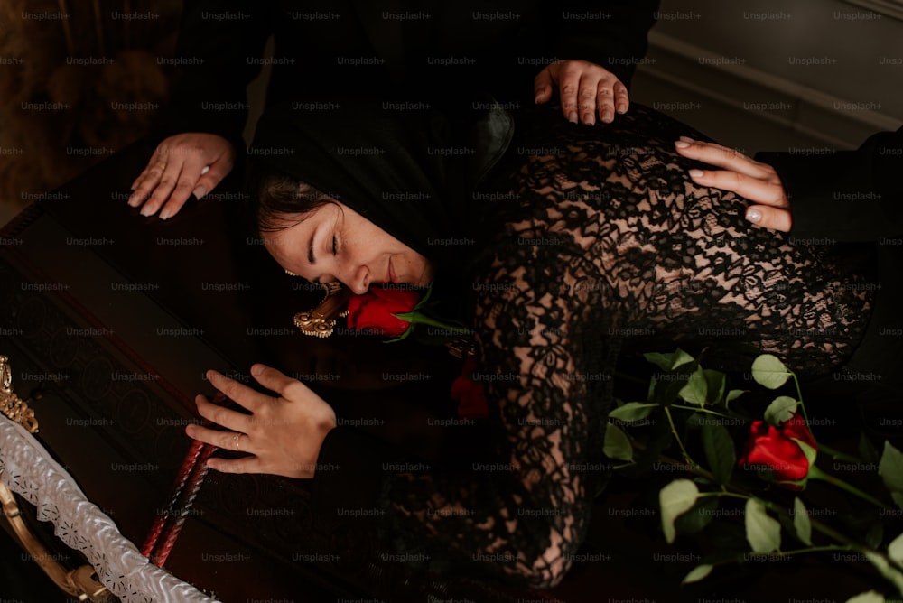 a woman laying on a table with a rose in her hand