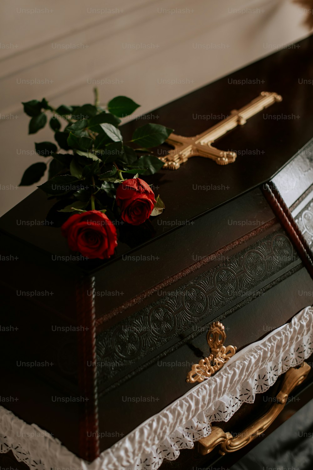una caja de madera con una cruz y rosas
