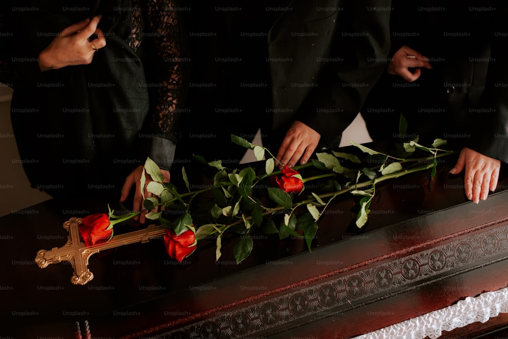 a group of people placing roses on a casket