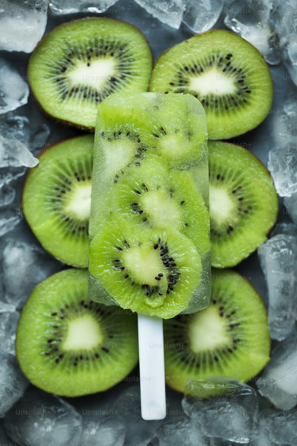 a popsicle with kiwi slices on top of ice