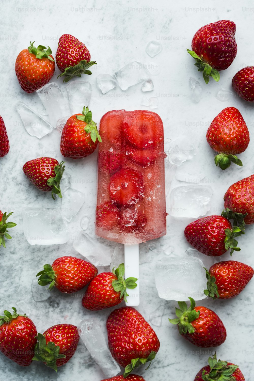 a popsicle with strawberries on top of ice