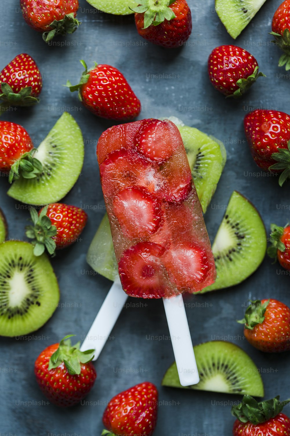 a popsicle with strawberries, kiwi and kiwi slices