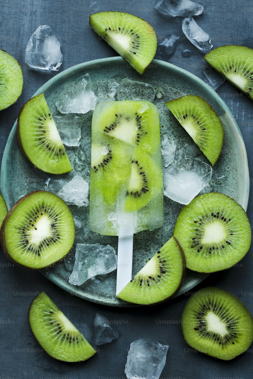 a green popsicle with kiwi slices on a plate