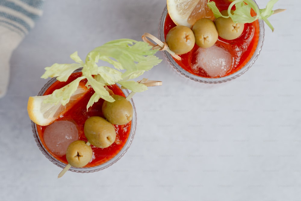 a couple of glasses filled with food on top of a table