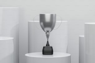 a silver trophy sitting on top of a white pedestal