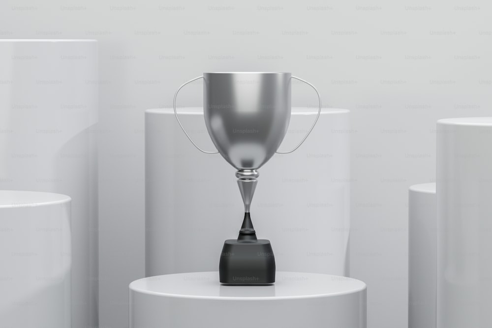 um troféu de prata sentado em cima de um pedestal branco