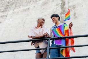 um homem e uma mulher segurando uma bandeira do arco-íris