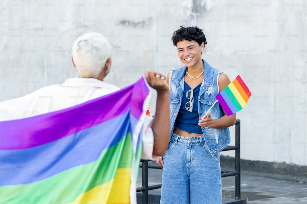a woman holding a rainbow flag next to a man