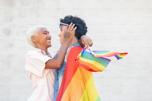Ein Mann und eine Frau halten eine Regenbogenfahne