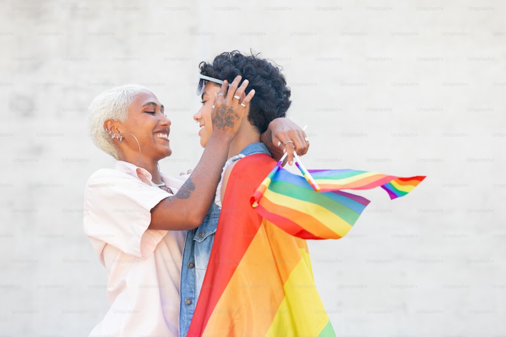 a man and a woman holding a rainbow flag