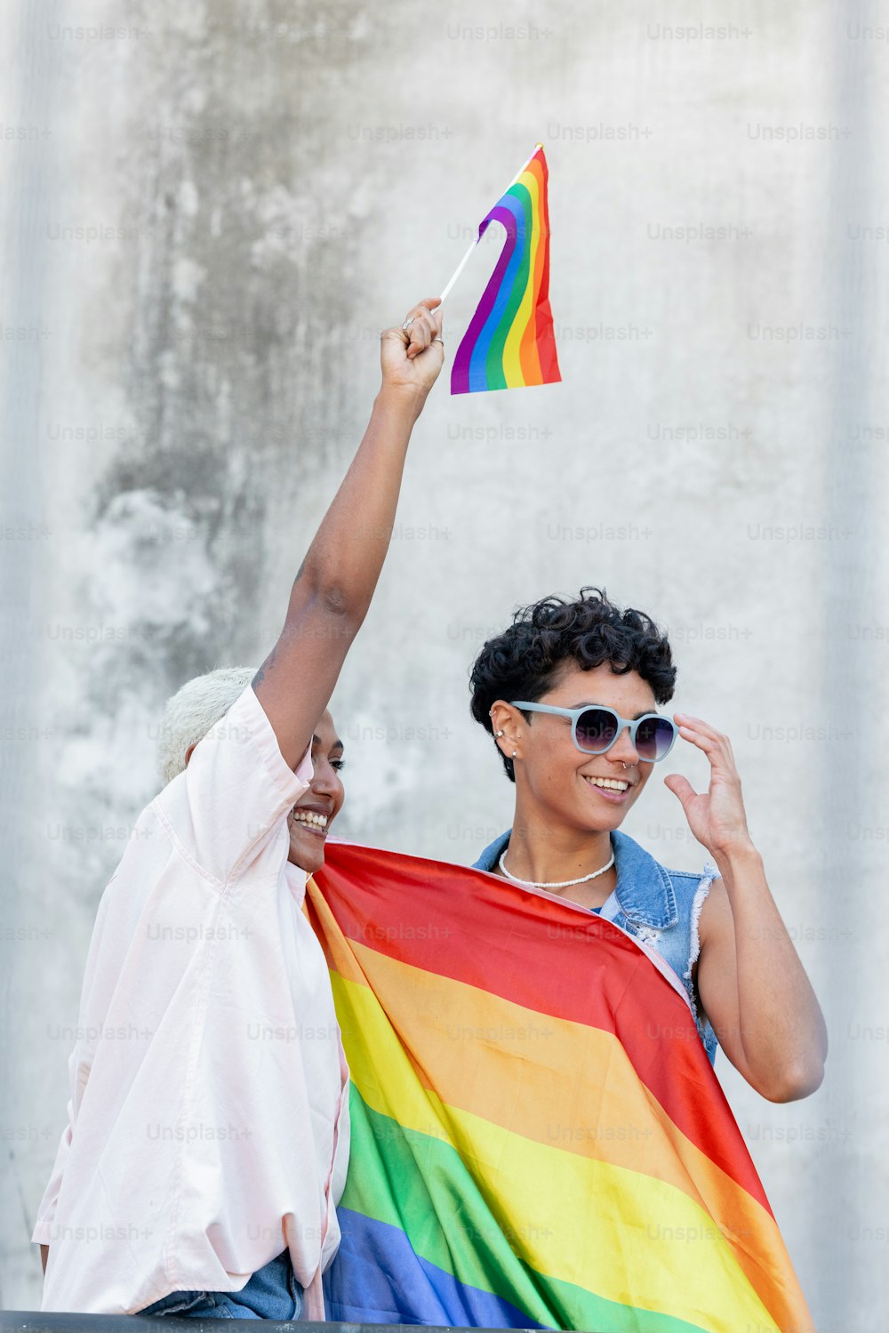 a man and a woman holding a rainbow flag
