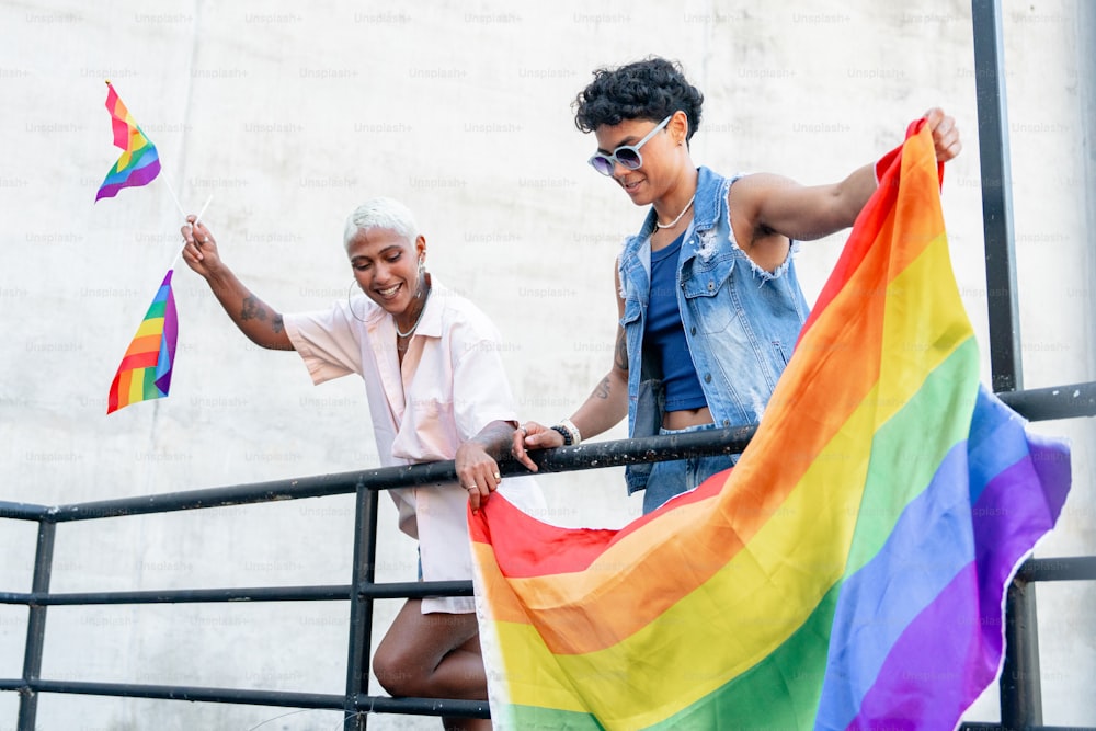 a man and a woman holding a rainbow flag