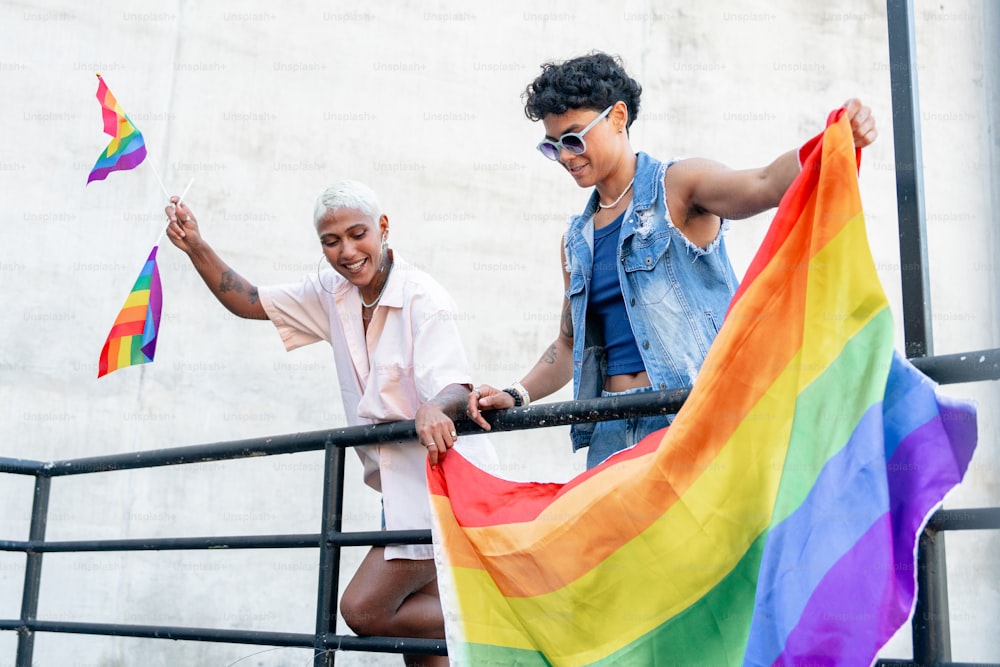 Un hombre y una mujer sosteniendo una bandera arcoíris