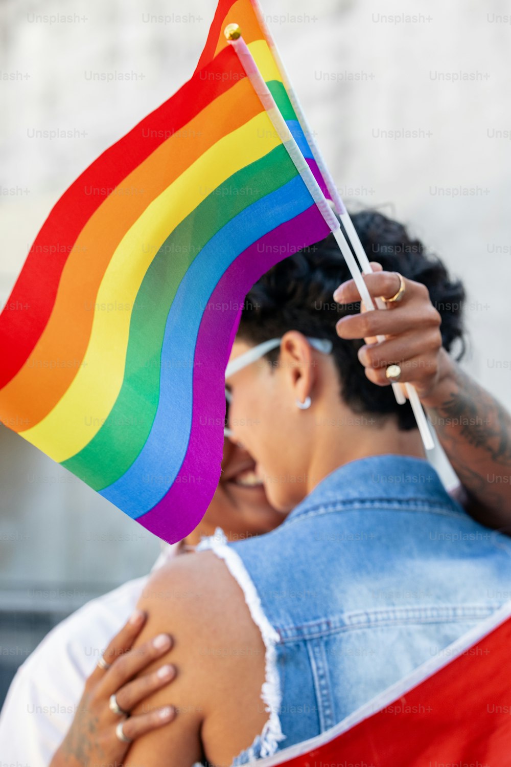 una mujer con una bandera arcoíris en la mano
