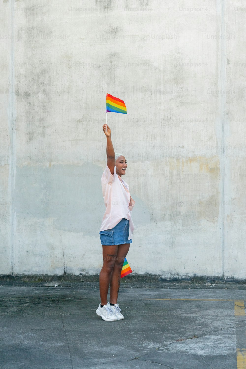 a woman holding a rainbow flag in the air