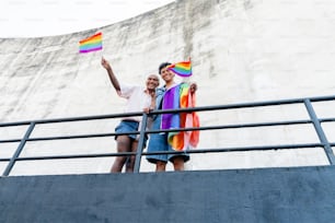 Un par de personas que sostienen una bandera arcoíris