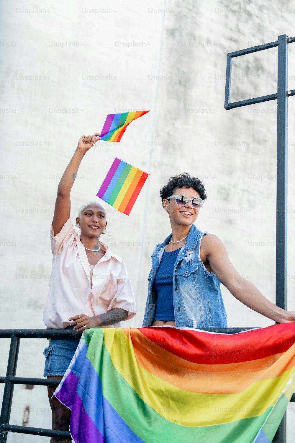 un paio di persone che tengono in mano una bandiera arcobaleno