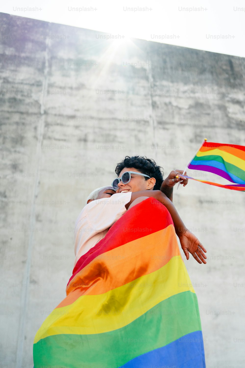 a woman holding a rainbow flag in front of a building