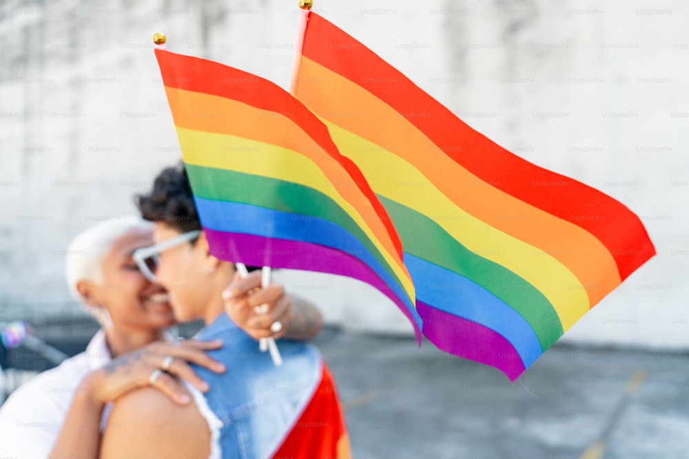 un uomo e una donna che tengono una bandiera arcobaleno