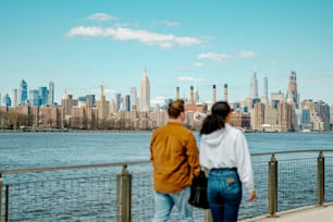 a man and a woman walking on a bridge near a body of water