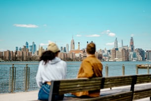 um homem e uma mulher sentados em um banco olhando para a cidade
