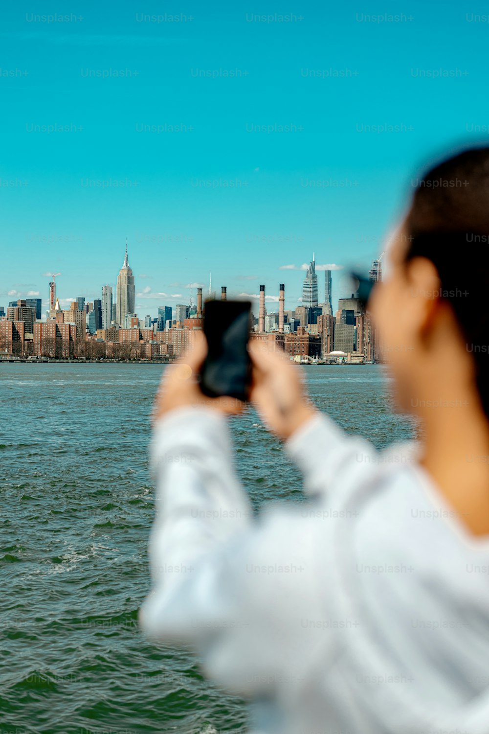 a woman taking a picture of a city skyline