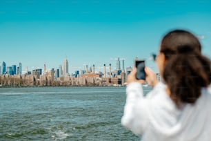 a woman taking a picture of a city skyline