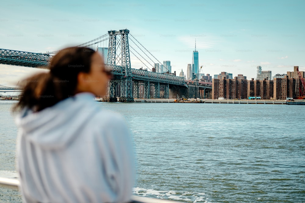 une femme regardant au-dessus de l’eau un pont