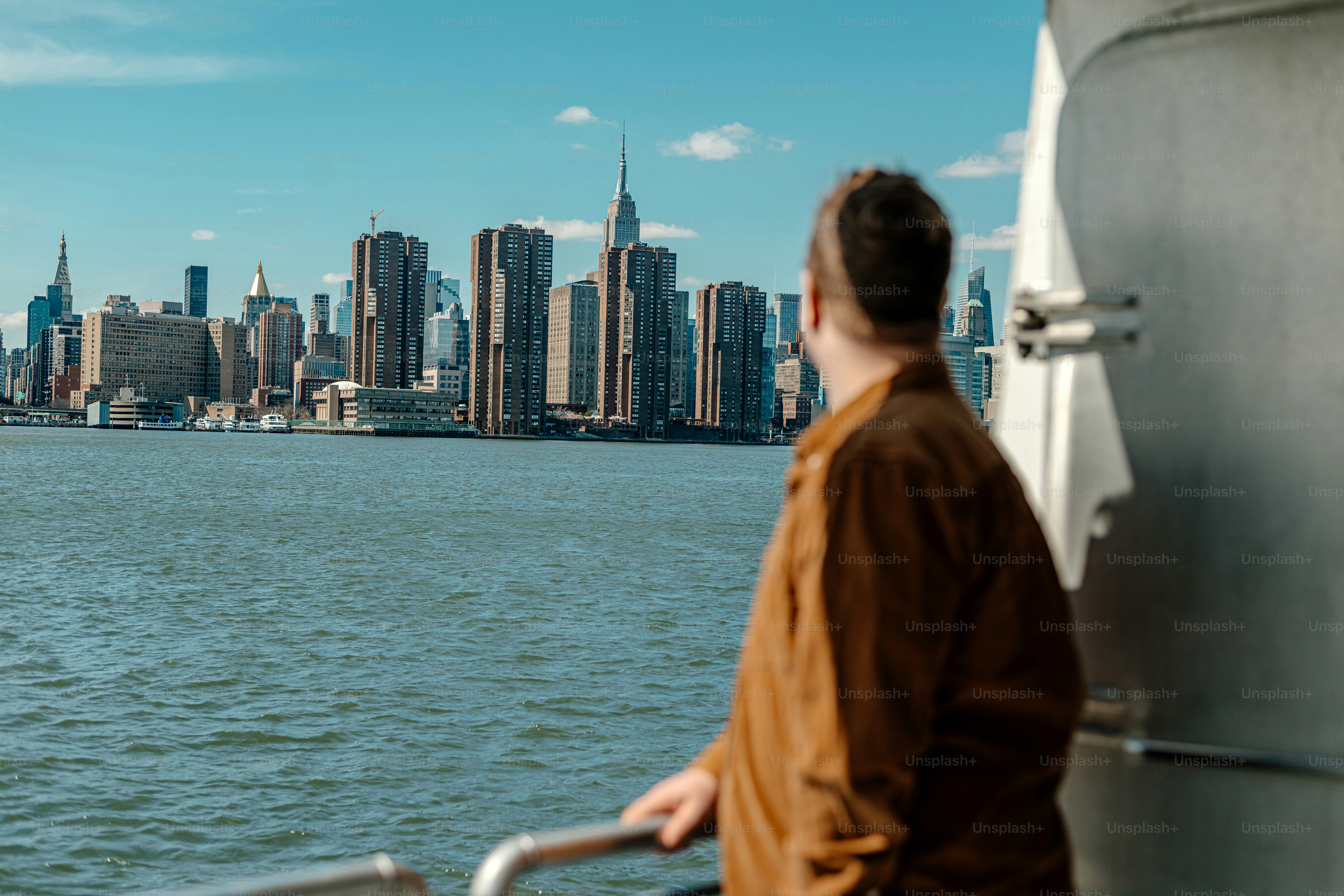 a man standing on a boat looking at the city