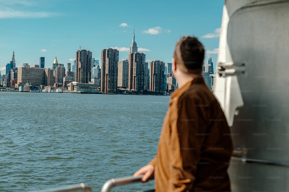 a man standing on a boat looking at the city