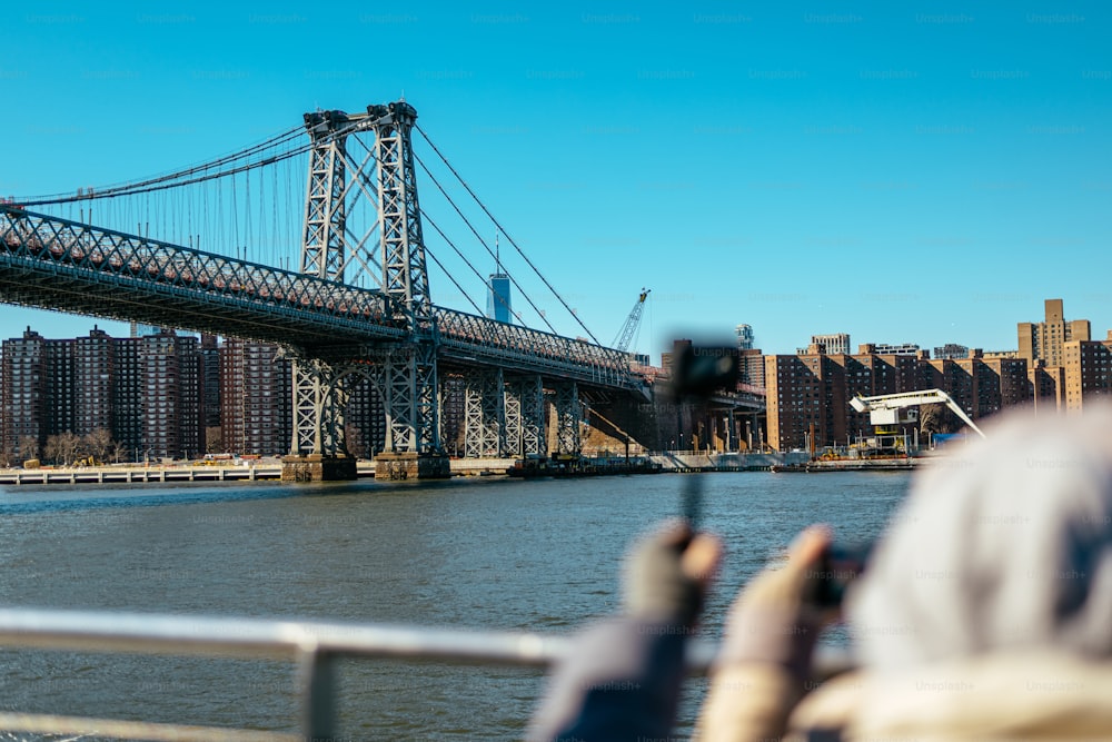 uma pessoa tirando uma foto de uma ponte