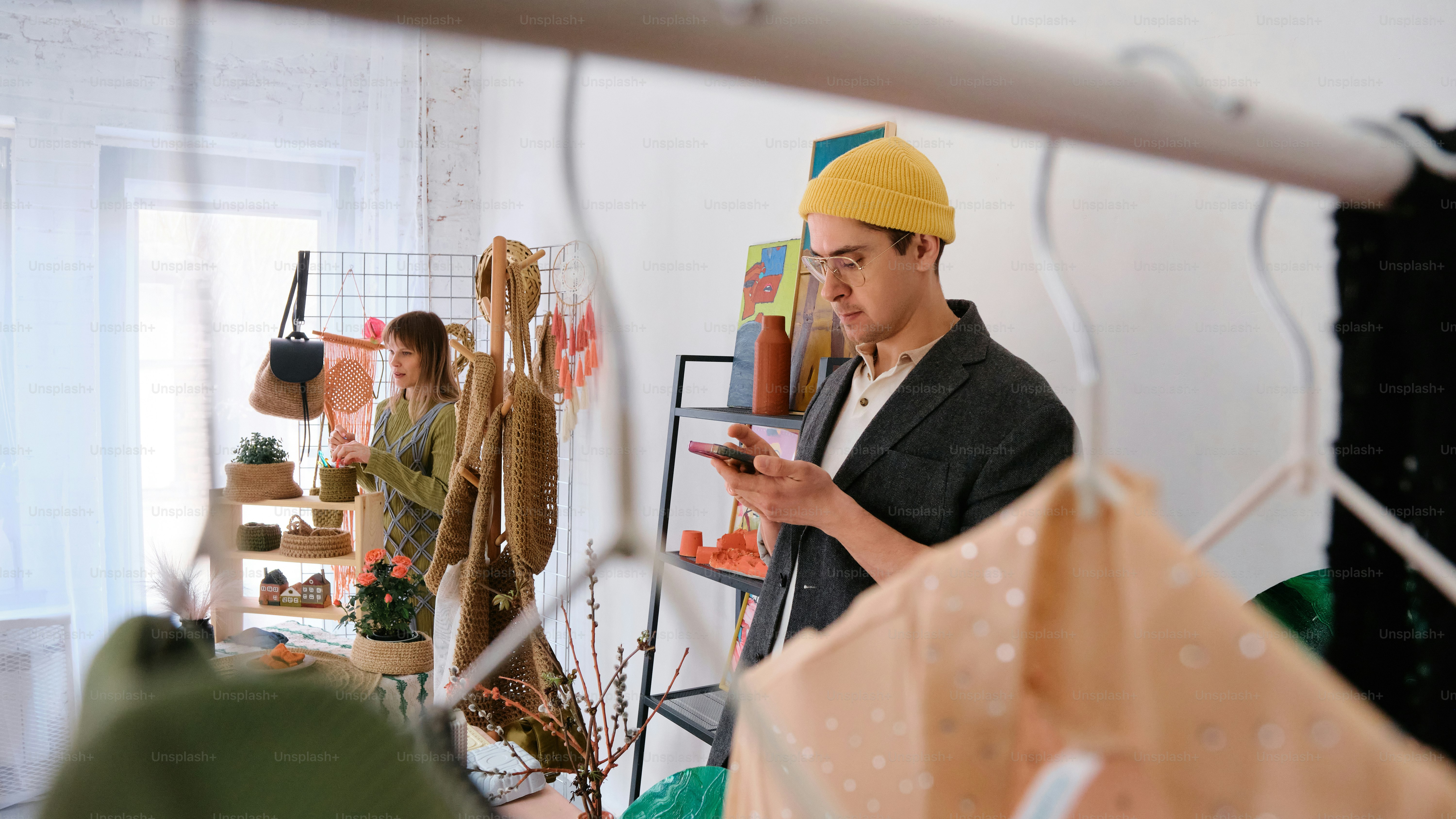 um homem de chapéu amarelo olhando para um celular