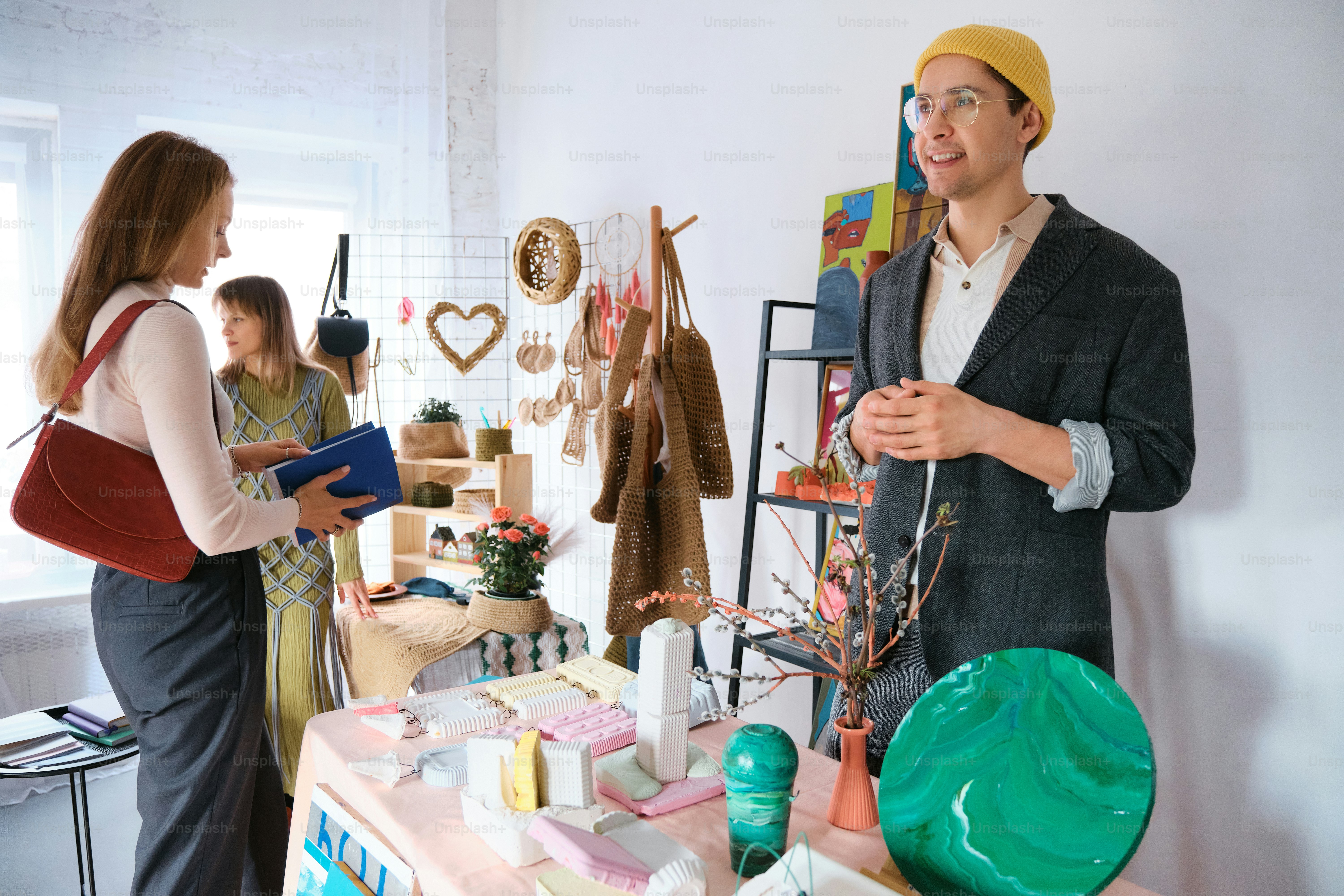 A man and a woman standing in front of a table photo – Craft fair Image ...