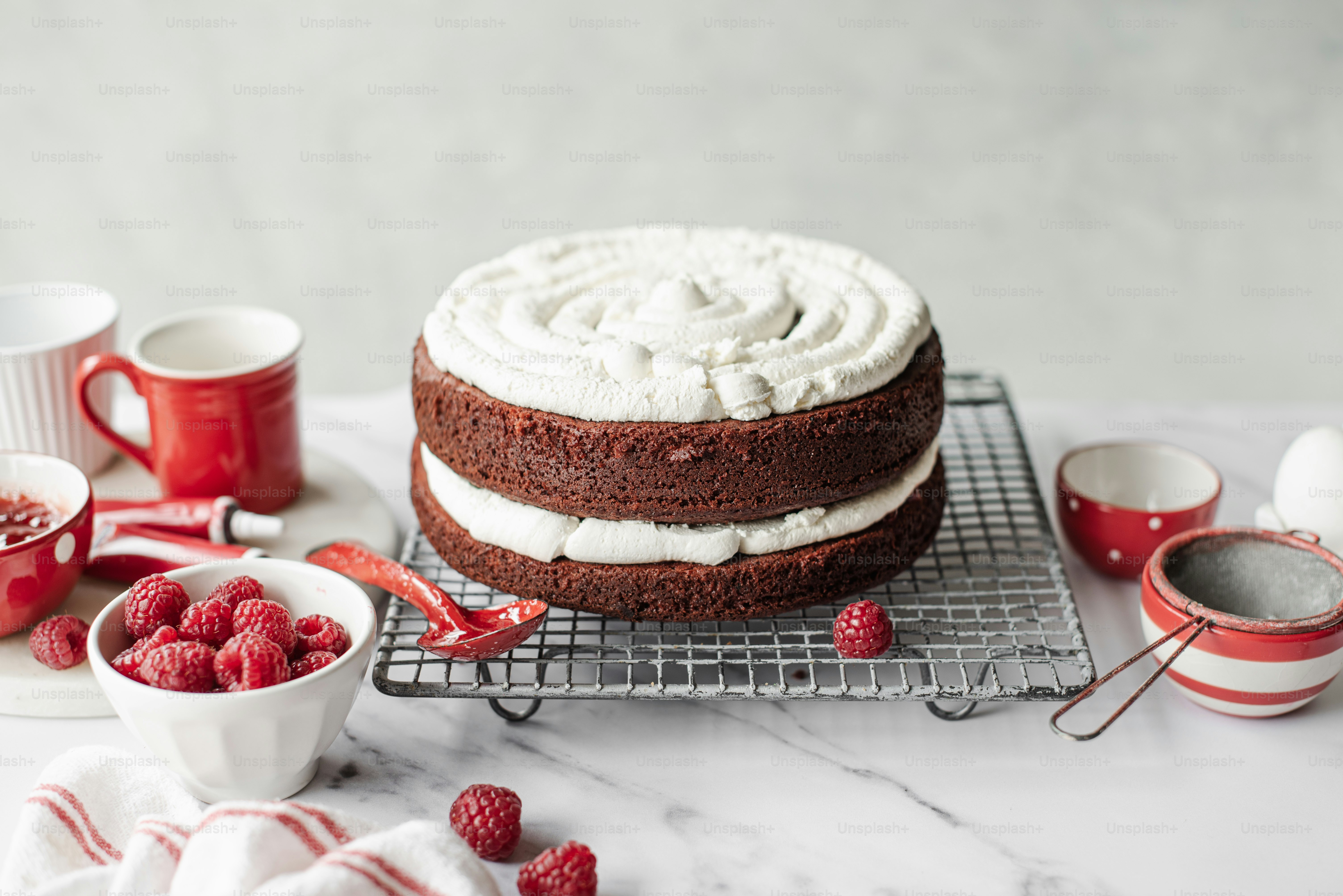 A person is decorating a cake with raspberries photo – Making cakes ...