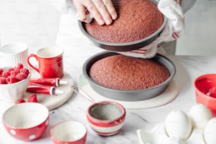 eine Frau dekoriert einen Kuchen mit Himbeeren