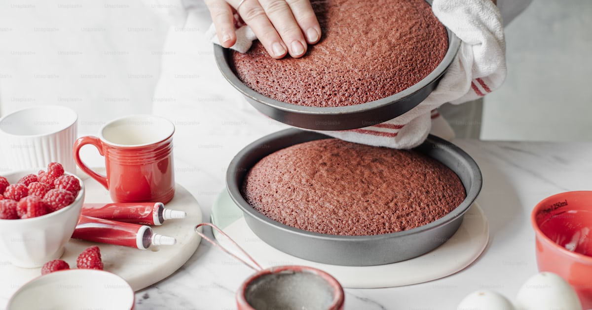 A woman is decorating a cake with raspberries photo – Food Image on ...