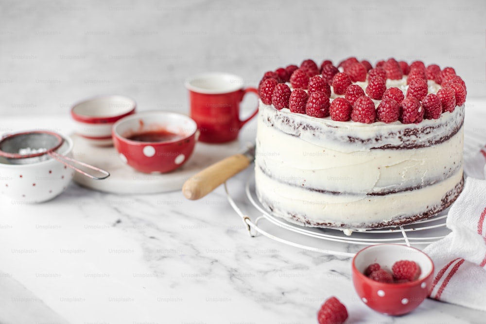 a cake with white frosting and raspberries on top