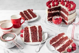 uma fatia de bolo red velvet com cobertura branca e framboesas