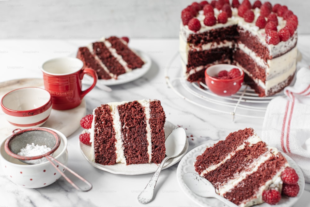 a slice of red velvet cake with white frosting and raspberries