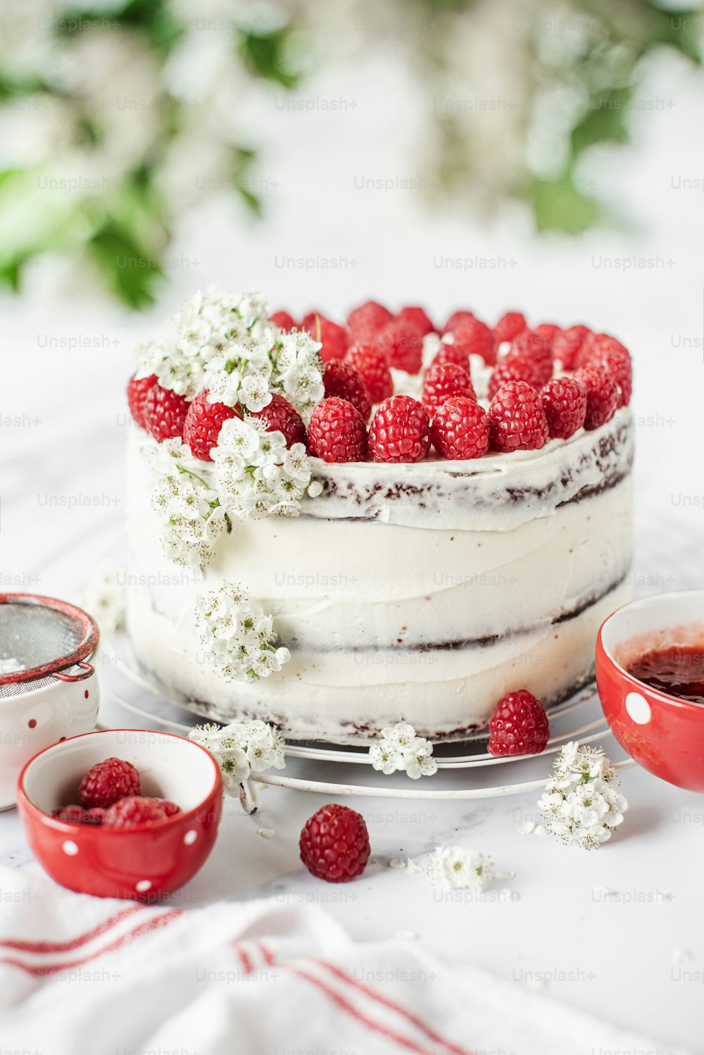 a cake with white frosting and raspberries on top