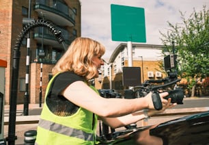 a woman in a safety vest is working on a car