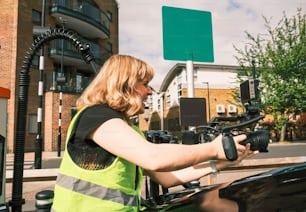 Uma mulher com um colete de segurança está trabalhando em um carro