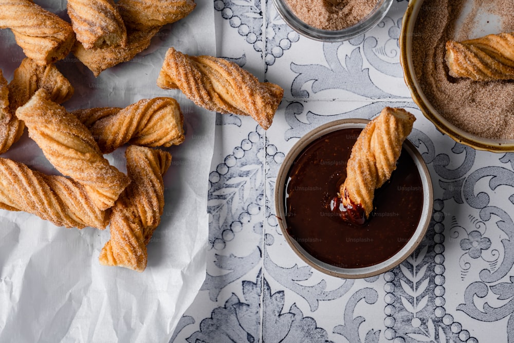 a bowl of dipping sauce next to a bowl of croissants